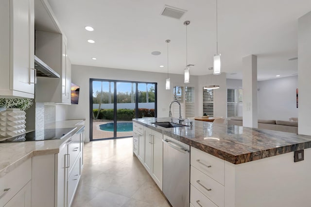 kitchen featuring sink, hanging light fixtures, stainless steel dishwasher, an island with sink, and white cabinets