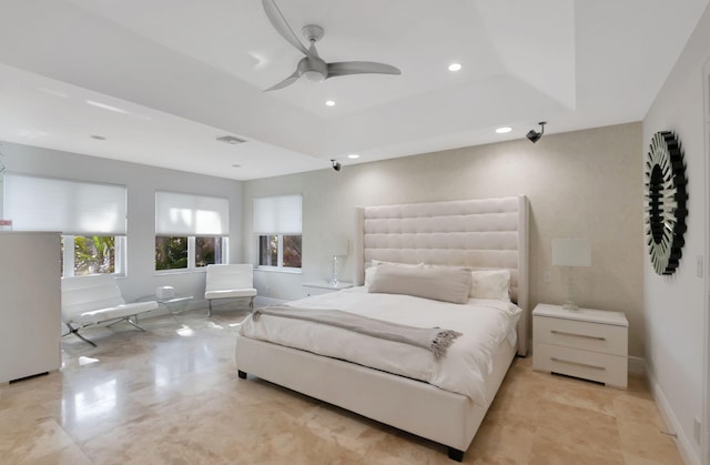 bedroom with a tray ceiling and ceiling fan