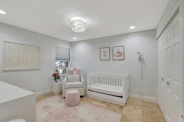 bedroom featuring a chandelier and a nursery area