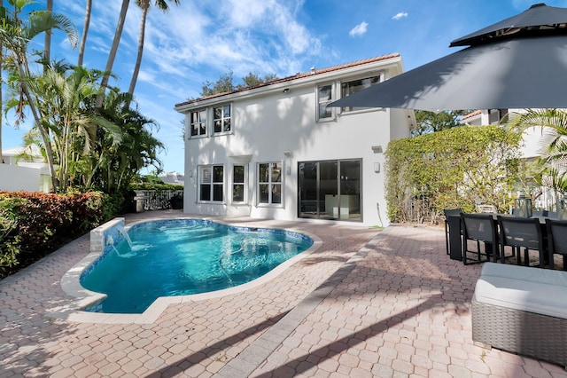 view of swimming pool featuring pool water feature and a patio