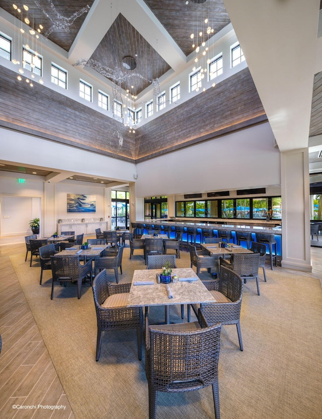 dining area featuring a towering ceiling and a chandelier