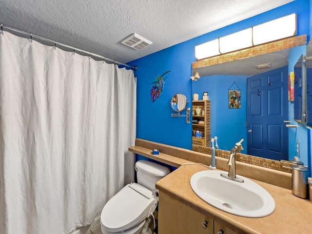 bathroom with oversized vanity, toilet, and a textured ceiling