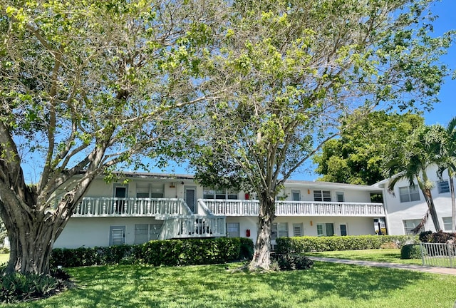 view of front of property with a front lawn and a balcony