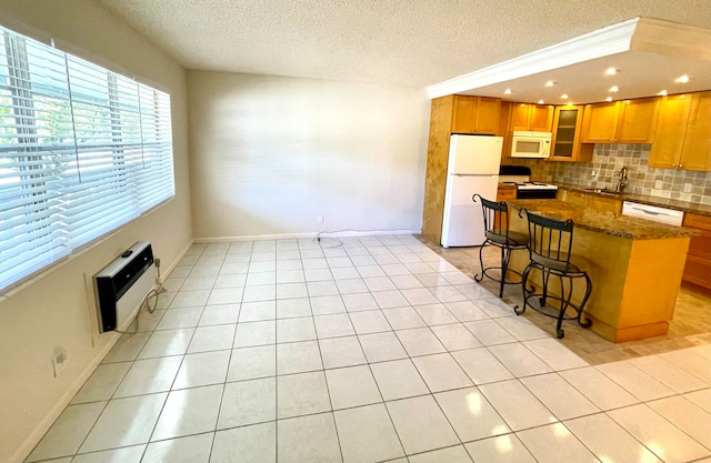 kitchen featuring backsplash, white appliances, dark stone counters, a breakfast bar, and light tile floors