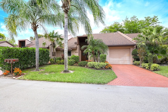 view of front of property with a garage and a front lawn