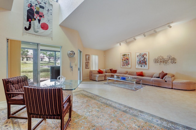 tiled living room with rail lighting and high vaulted ceiling