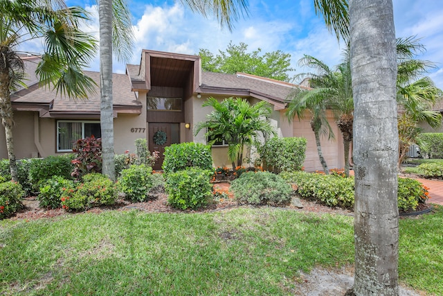 view of front of house featuring a front lawn and a garage