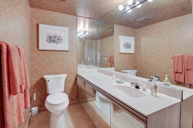 bathroom featuring tile flooring, tile walls, vanity, and toilet