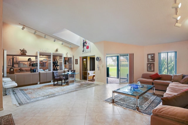 living room with rail lighting, vaulted ceiling, and light tile floors