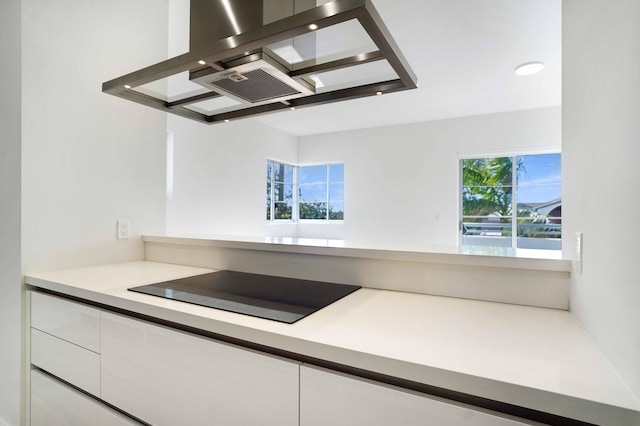 kitchen with black electric cooktop, ventilation hood, and white cabinets