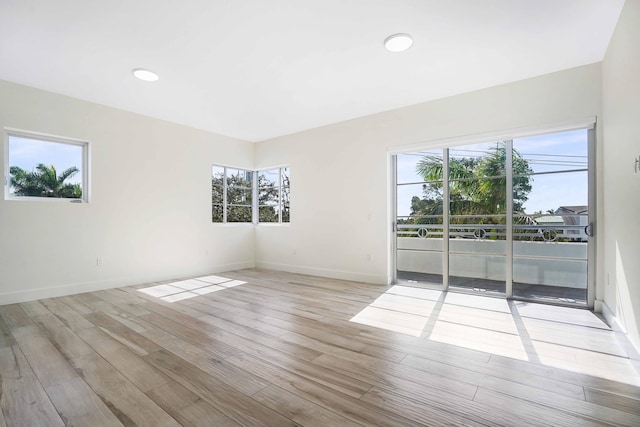 unfurnished room with a wealth of natural light and light hardwood / wood-style floors