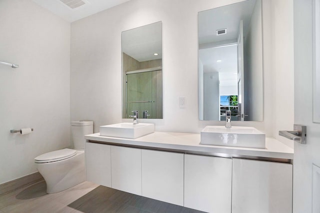 bathroom with vanity, an enclosed shower, and toilet