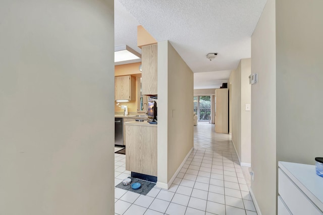 hall with light tile patterned floors, a textured ceiling, and sink