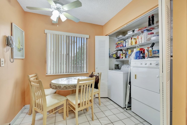 laundry area featuring ceiling fan, light tile patterned flooring, washer and dryer, and a textured ceiling