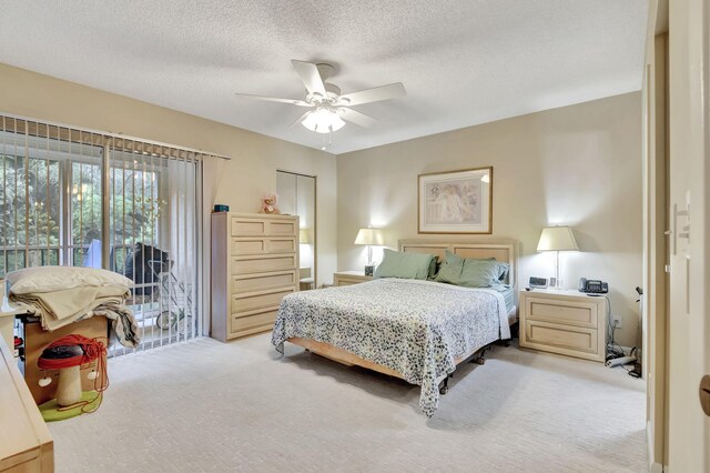 carpeted bedroom featuring access to exterior, ceiling fan, and a textured ceiling