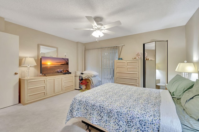 carpeted bedroom with ceiling fan and a textured ceiling