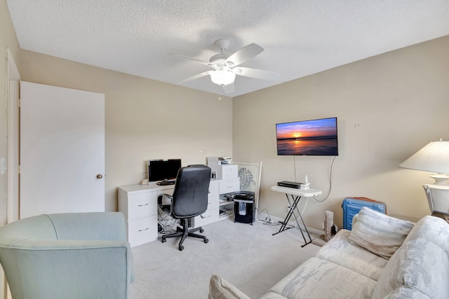 carpeted office with a textured ceiling and ceiling fan