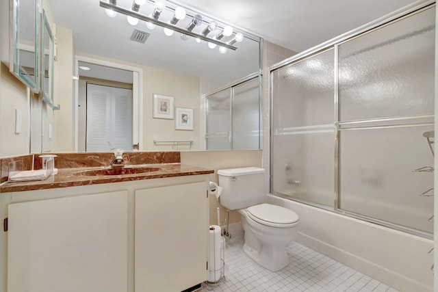 full bathroom with tile patterned flooring, vanity, toilet, and bath / shower combo with glass door