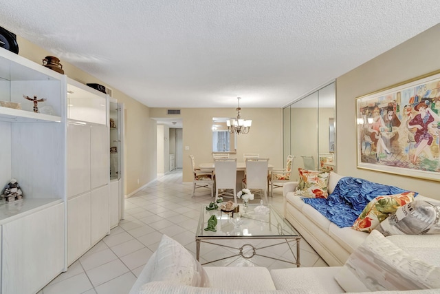 tiled living room with a textured ceiling and a chandelier