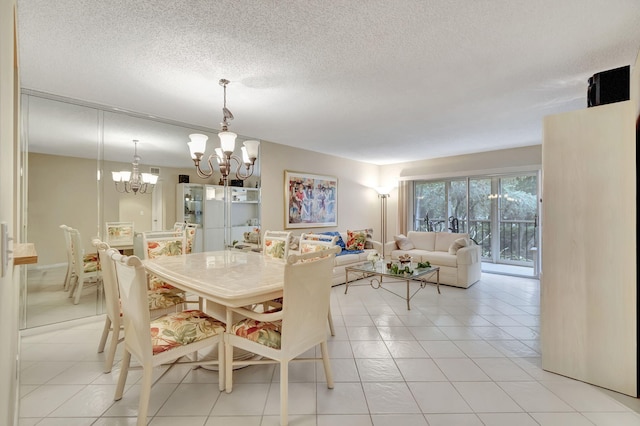 tiled dining room featuring a chandelier and a textured ceiling