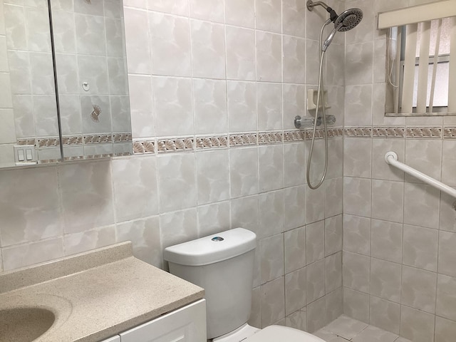 bathroom featuring vanity with extensive cabinet space, tiled shower, toilet, and tile walls