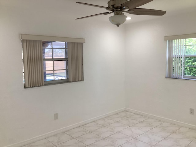 tiled empty room featuring ceiling fan