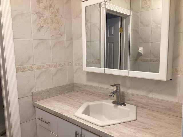 bathroom with vanity and tile walls