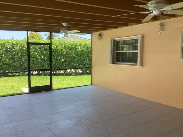 unfurnished sunroom with beamed ceiling and ceiling fan