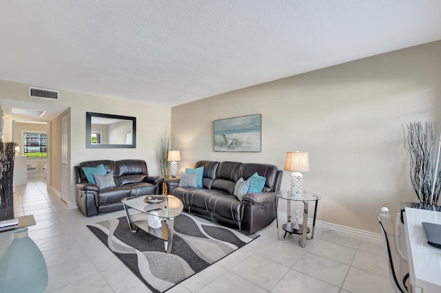 living room featuring a textured ceiling and light tile floors