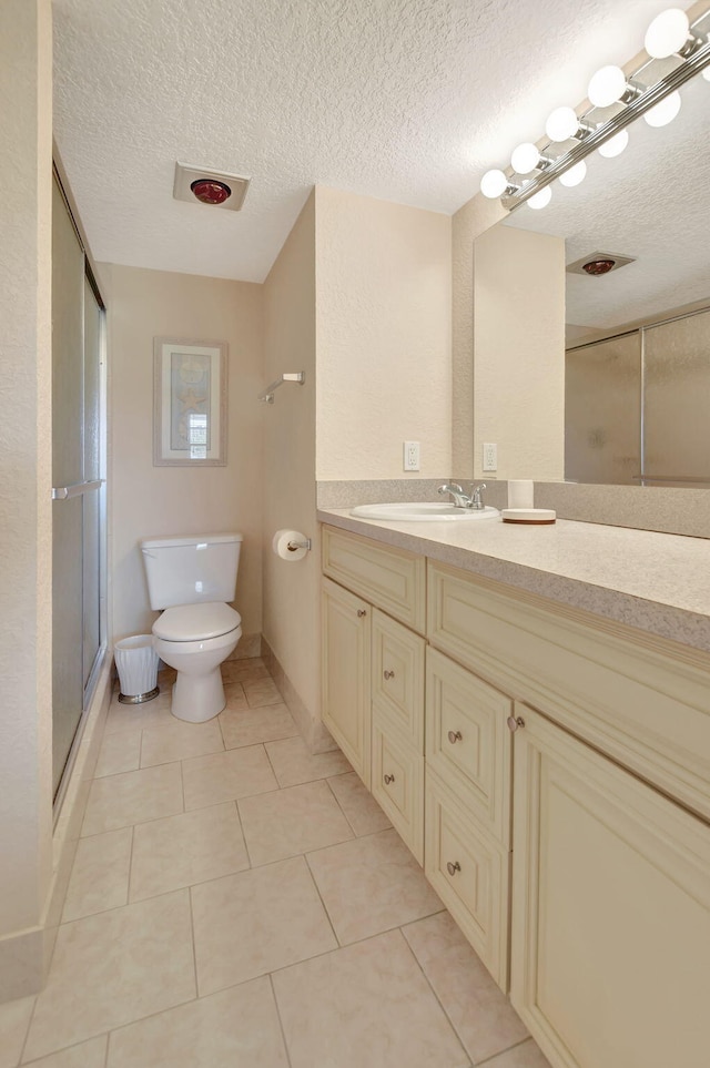 bathroom with vanity, tile flooring, a textured ceiling, and toilet