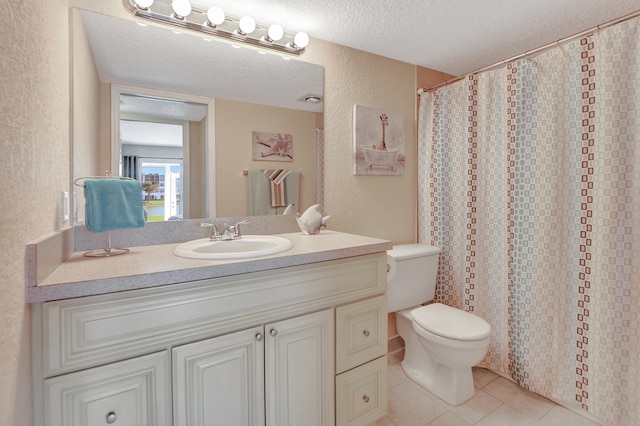 bathroom featuring toilet, a textured ceiling, tile flooring, and vanity