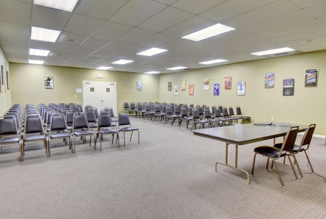 carpeted dining area featuring a drop ceiling