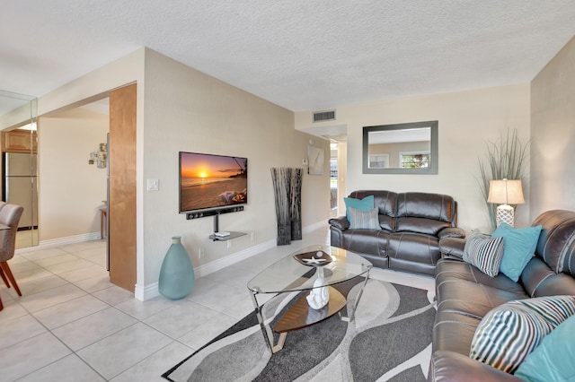 living room with a textured ceiling and light tile flooring