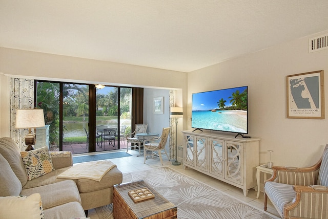 living room with a water view and light tile floors