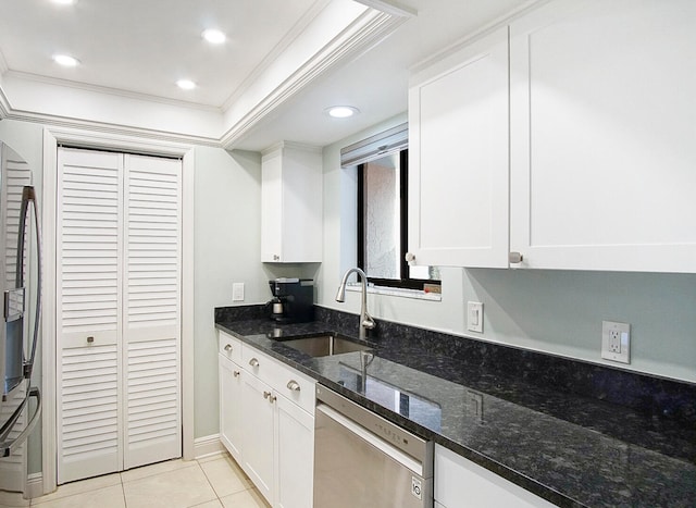 kitchen featuring white cabinets, dark stone counters, stainless steel dishwasher, and sink