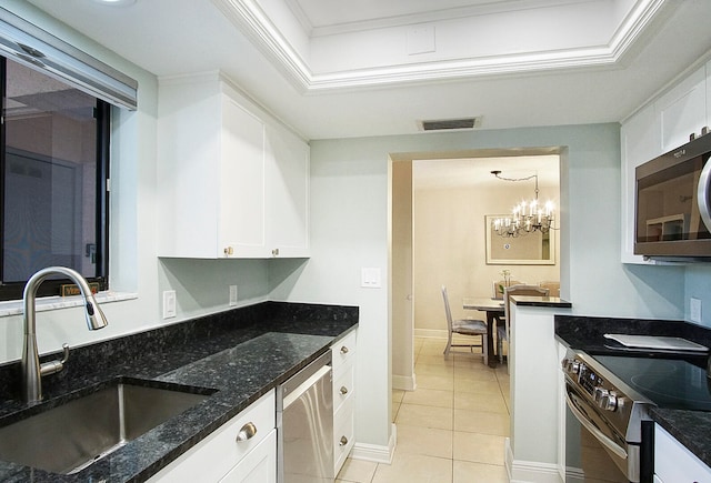 kitchen featuring sink, white cabinets, dark stone countertops, a chandelier, and stainless steel appliances