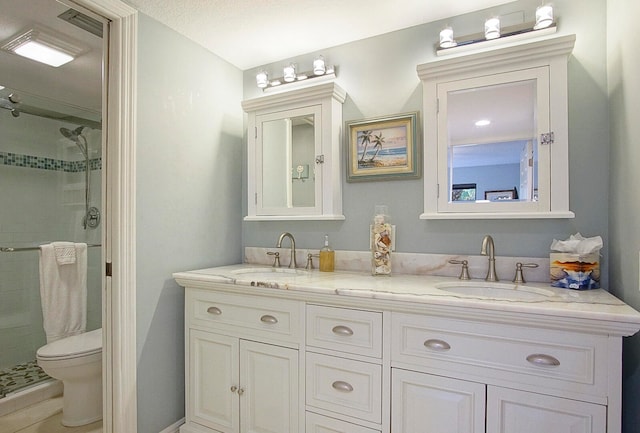 bathroom with toilet, dual bowl vanity, a shower with shower door, and a textured ceiling