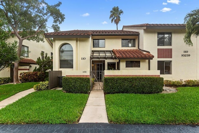 mediterranean / spanish-style home featuring a front yard