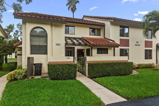 mediterranean / spanish home with a front yard