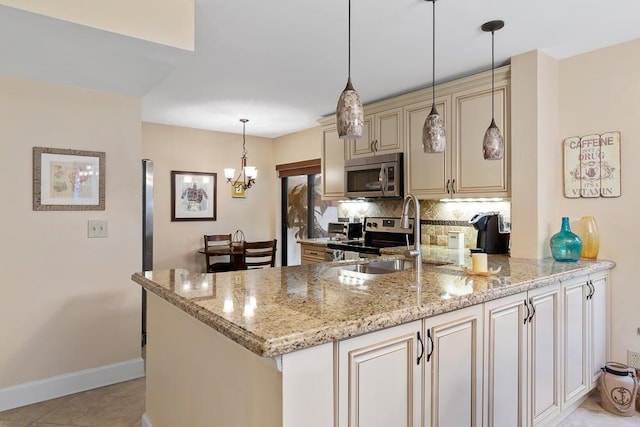 kitchen featuring stainless steel appliances, tasteful backsplash, pendant lighting, light stone counters, and cream cabinets