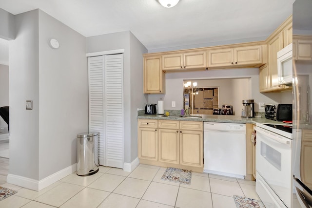 kitchen featuring light brown cabinets, white appliances, light tile floors, and a chandelier