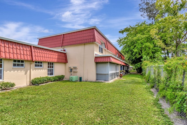 exterior space with central AC and a yard