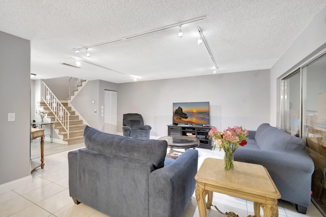 tiled living room with rail lighting and a textured ceiling