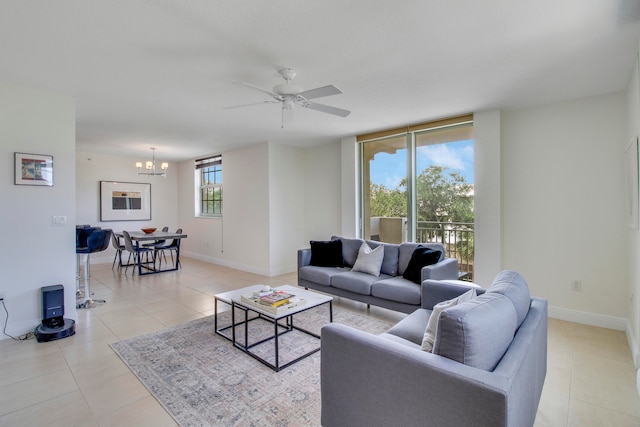 tiled living room featuring ceiling fan with notable chandelier