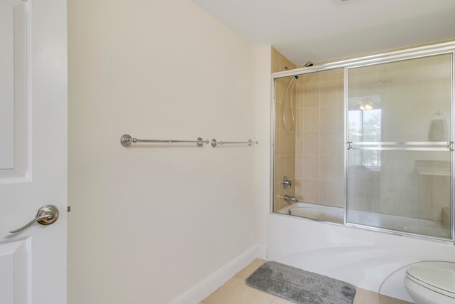 bathroom with tile flooring, bath / shower combo with glass door, and toilet