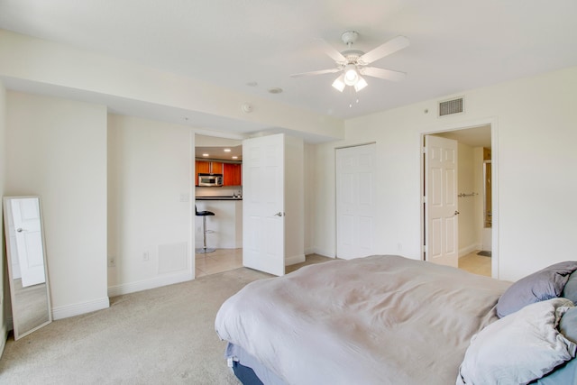 carpeted bedroom featuring ensuite bath and ceiling fan