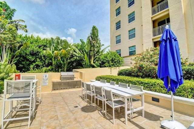 view of patio / terrace featuring a balcony, area for grilling, and exterior kitchen