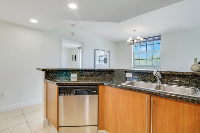 kitchen featuring a chandelier, light tile floors, dark stone counters, dishwasher, and sink