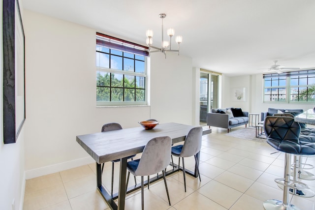 tiled dining area featuring ceiling fan with notable chandelier