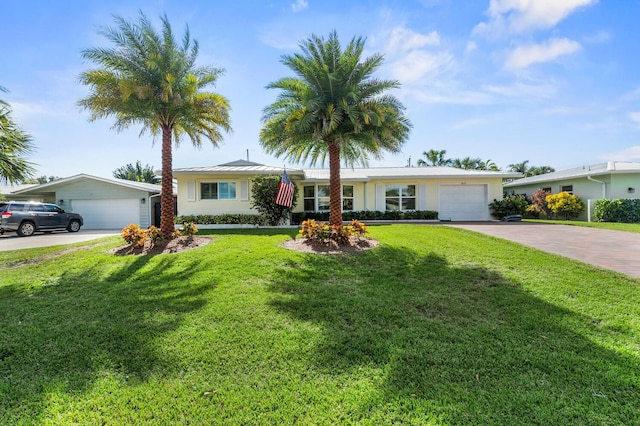 ranch-style home featuring a standing seam roof, metal roof, decorative driveway, and a front yard